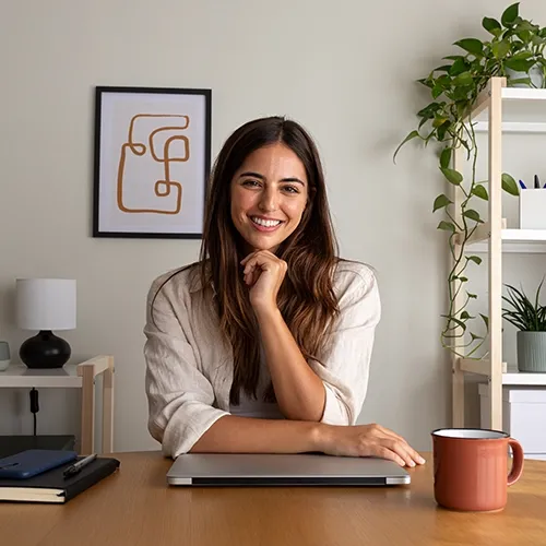 smiling woman with her laptop on desk